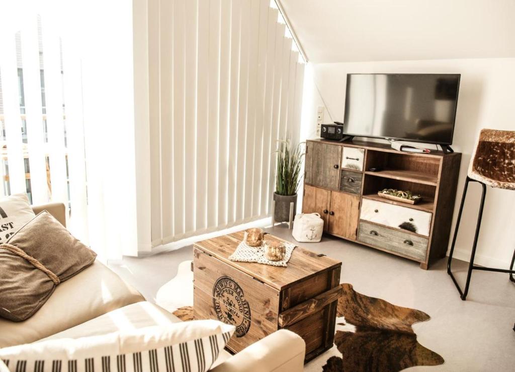 a living room with a couch and a tv at Achtern Diek in Büsum