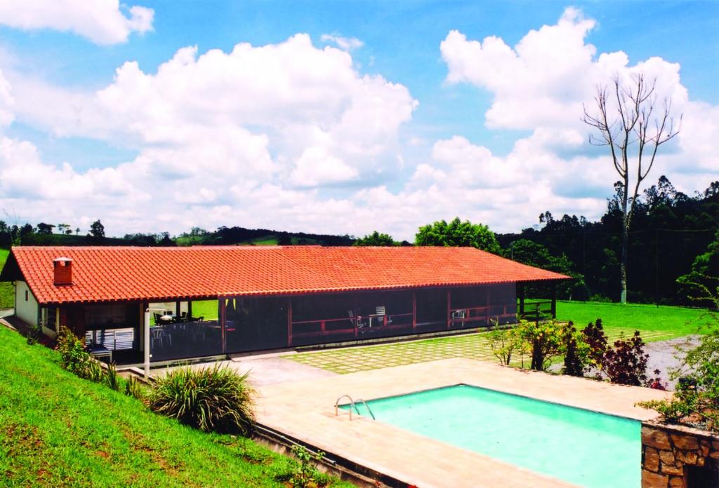 una casa con piscina frente a ella en CHACARA PRIMAVERAS en Jarinu