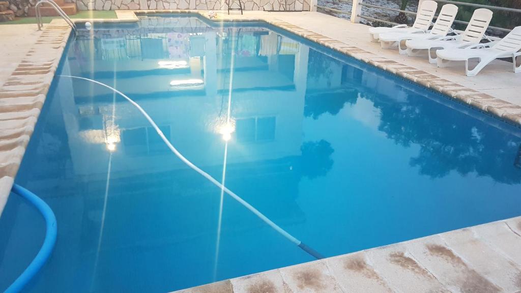 una piscina con sillas y agua azul en Calicanto House & Pool, en Torrent