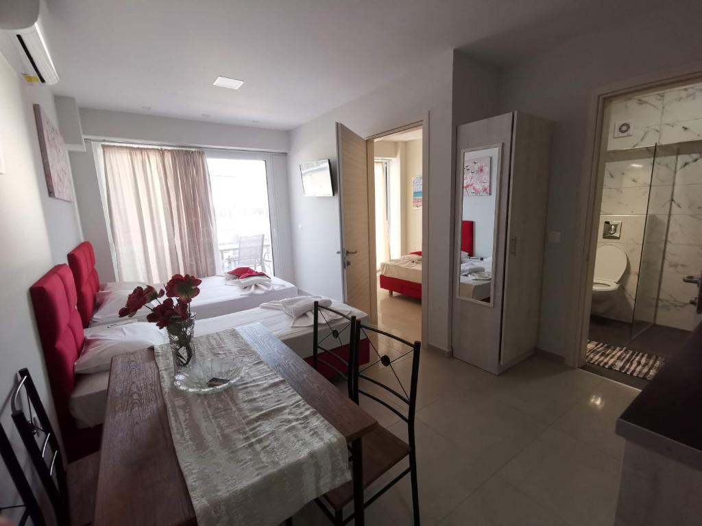 ein Wohnzimmer mit einem Tisch und einem Bett in der Unterkunft Milla Lux 3 in Paralia Katerinis