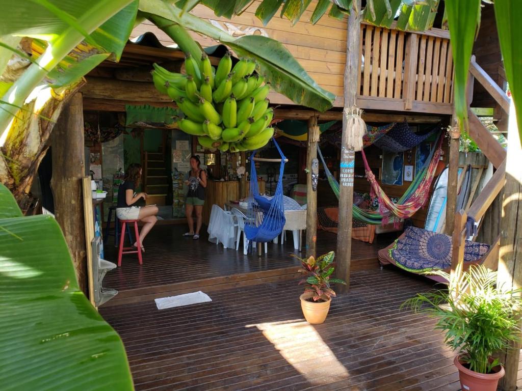 un porche de una casa con un montón de bananas en Guarda Encantada Surf Hostel, en Guarda do Embaú