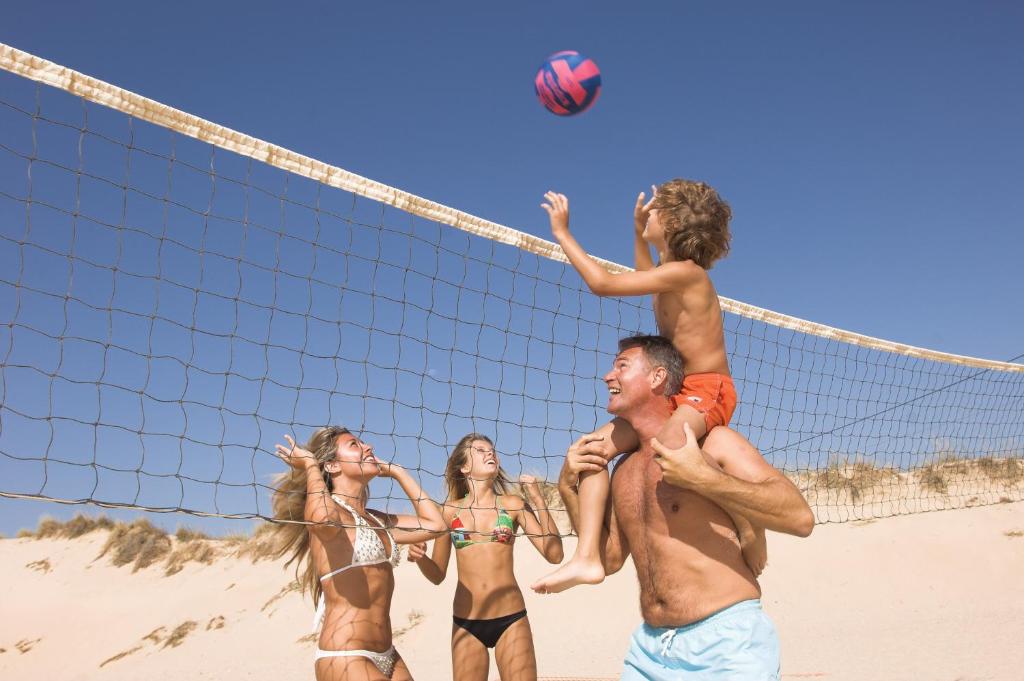 a group of people playing volleyball on the beach at Sagres Time Apartamentos in Sagres