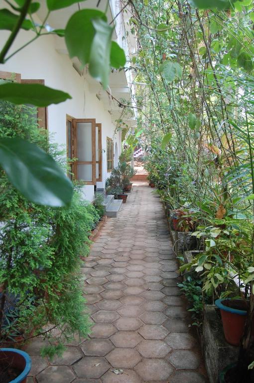 a walkway in a building with plants on it at Jickys Nest in Varkala