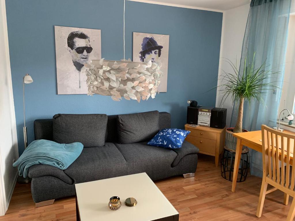 a living room with a couch and a blue wall at Zwischen (Messe) Köln u Düsseldorf ruhig u zentral in Langenfeld
