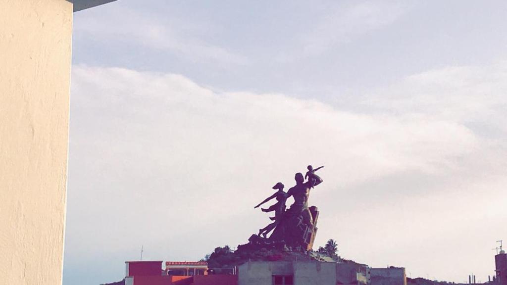 a statue with three people on top of it at Résidence ESSOWE-SIM in Dakar