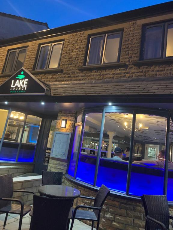 a table and chairs outside of a restaurant at night at Lake Lounge Rooms in Littleborough