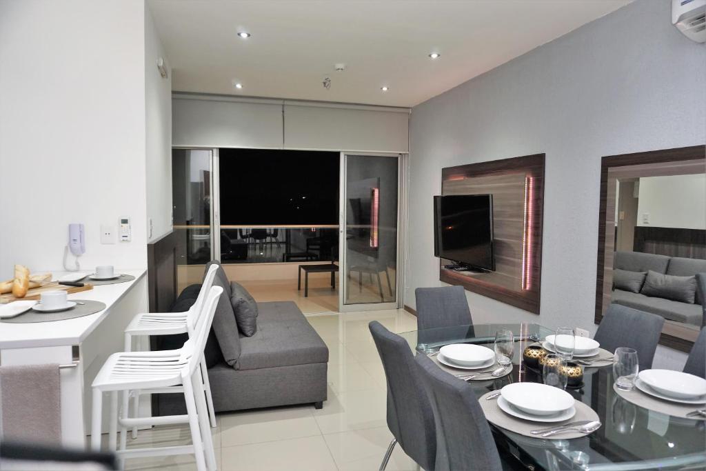 a kitchen and living room with a table and chairs at Asuncion Gracia Suites in Asunción