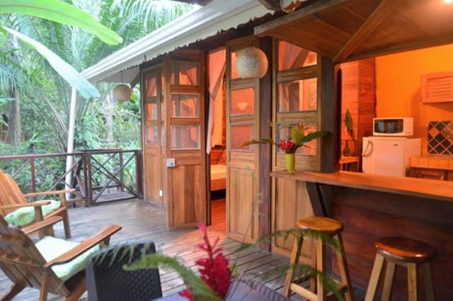 
a kitchen filled with furniture and a table at Pachamama Jungle River Lodge - Punta Uva in Puerto Viejo

