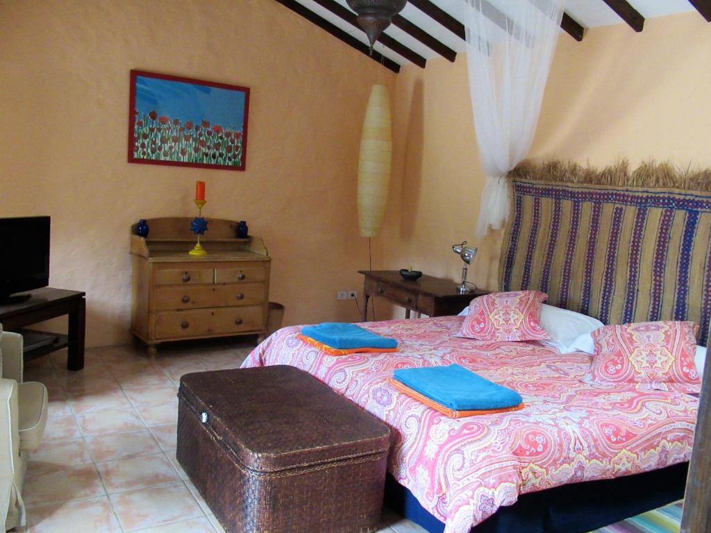 - une chambre avec un lit, une commode et une télévision dans l'établissement Encantadora Casa con piscina privada en el Risco de Agaete, à Agaete