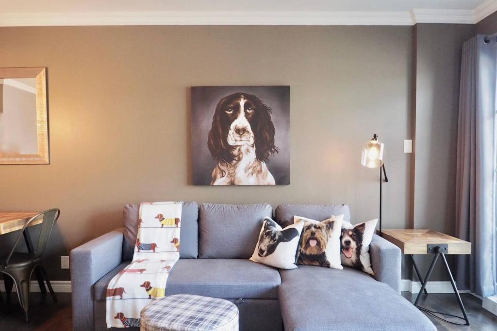 salon z niebieską kanapą ze zdjęciem psa w obiekcie INITIAL - MAITRE - Chutes-Montmorency w mieście Boischâtel