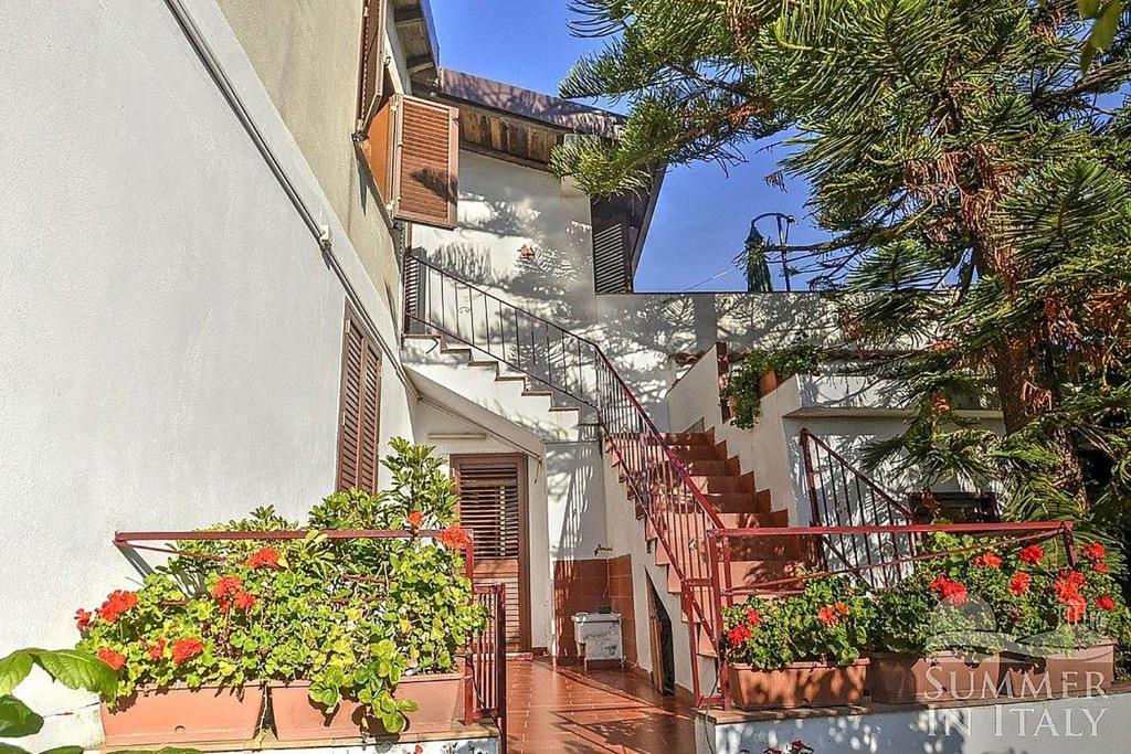 un bâtiment avec des boîtes de fleurs et des escaliers avec des fleurs dans l'établissement Casavacanzeinsicilia Etna Taormina, à Piedimonte Etneo