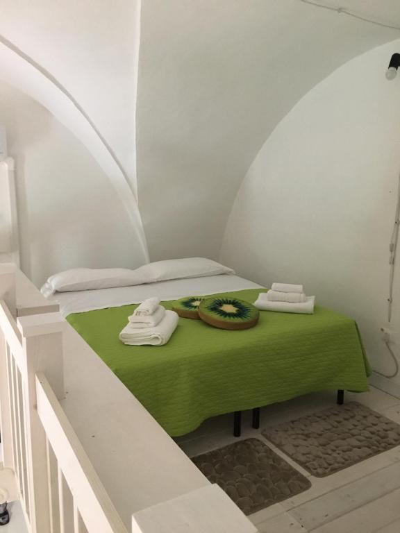 Cette chambre comprend un lit avec une couverture verte. dans l'établissement casa della notara, à Alezio