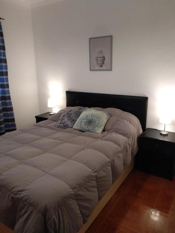 a bedroom with a large bed with two night stands at Ezeiza Home in Ezeiza