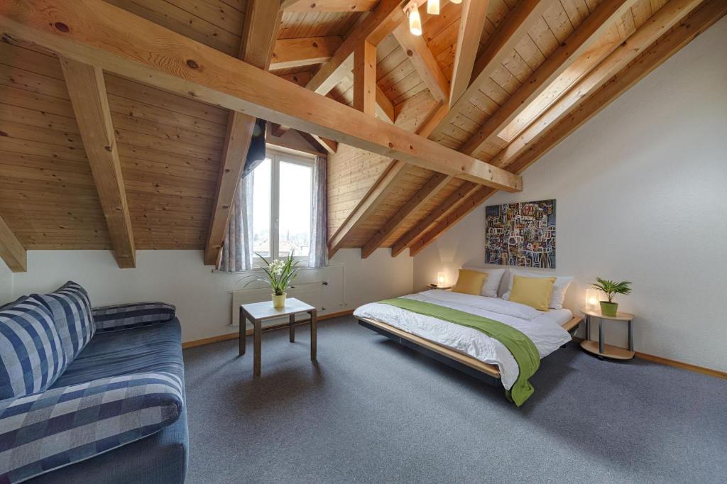 ein Schlafzimmer mit einem Bett und einem Sofa in der Unterkunft Hotel Blume Interlaken in Interlaken