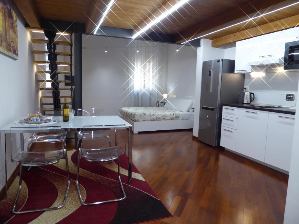 eine Küche mit einem Tisch und Stühlen sowie einem Kühlschrank in der Unterkunft Giudei House Suite Bologna in Bologna