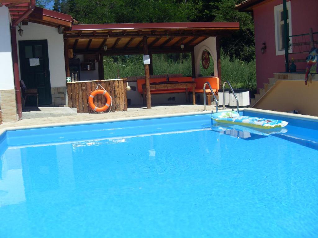 una gran piscina azul junto a una casa en The Pink House, en Polkownik Serafinowo