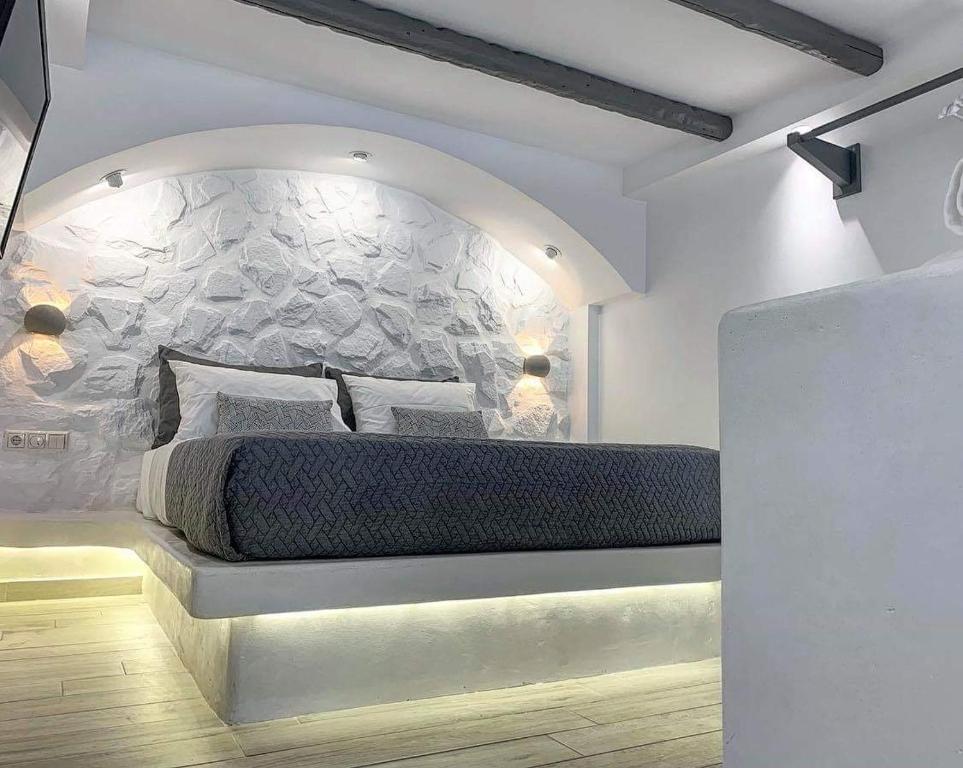 um quarto com uma cama grande e uma parede de pedra em Marina's Suites em Naxos Chora