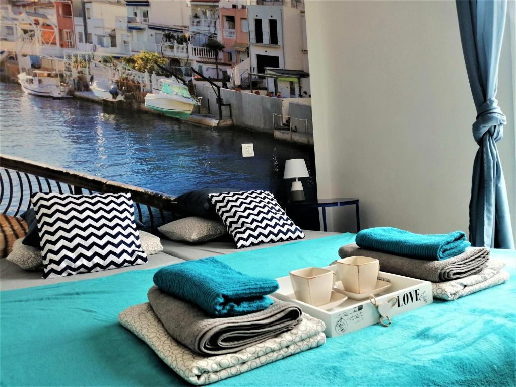 a room with a bed with towels and a view of the water at Unigue Design Apartment, Gandia in Gandía