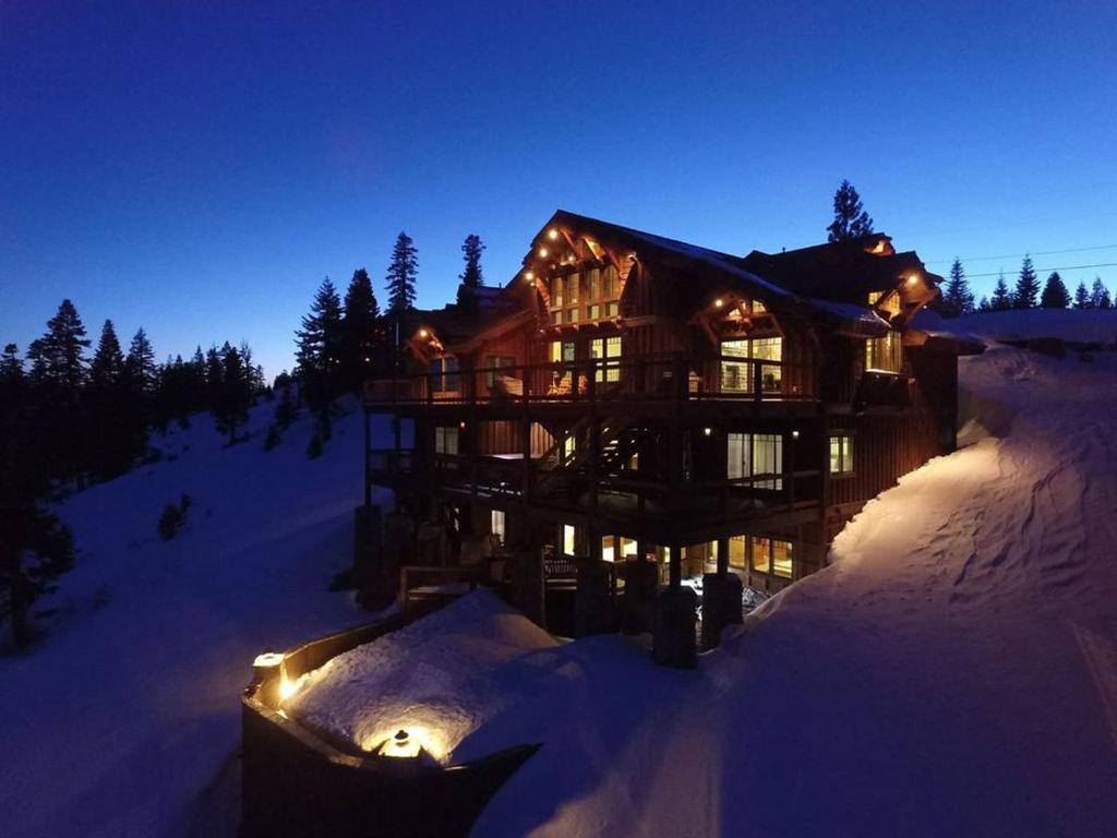 a large house in the snow at night at Skislope-Tahoe Villa in Truckee