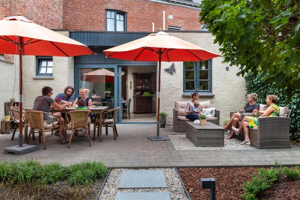 a group of people sitting at tables under umbrellas at Stadshuisje 36 in Hasselt
