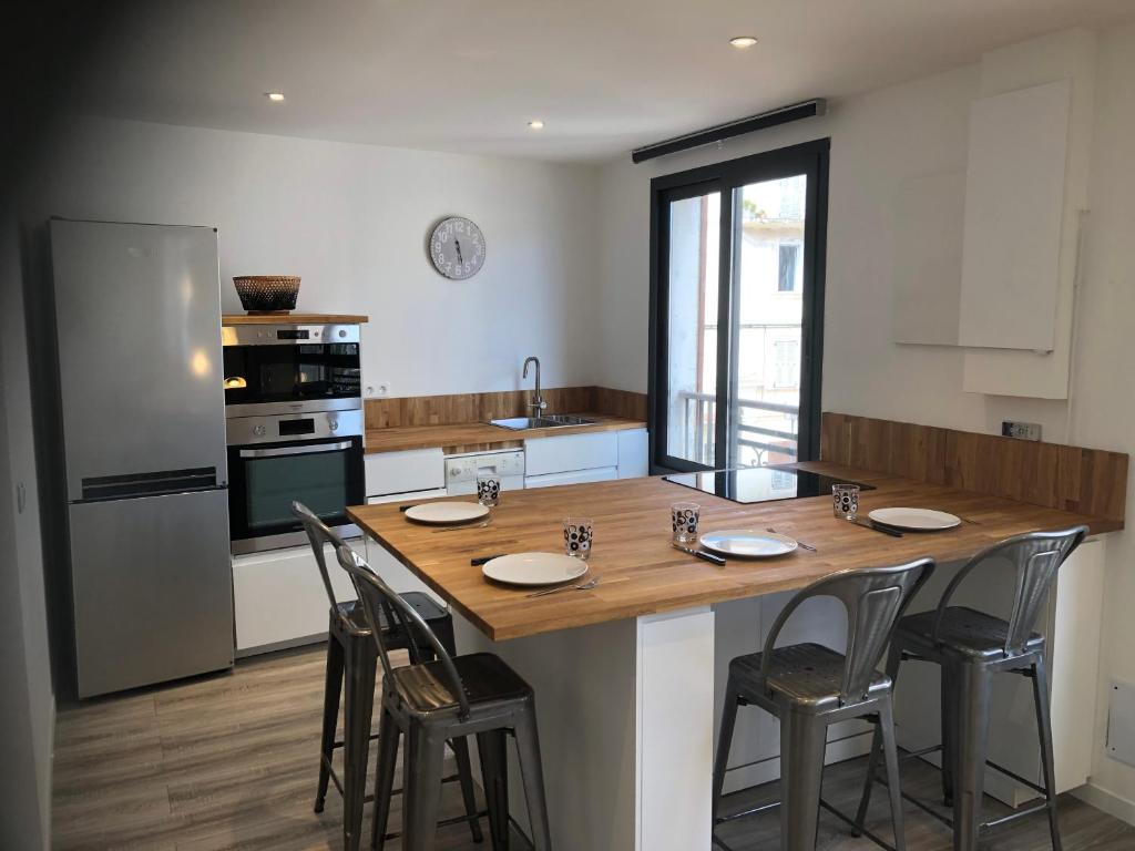 uma cozinha com uma grande mesa de madeira e cadeiras em Appartement port bonifacio em Bonifacio