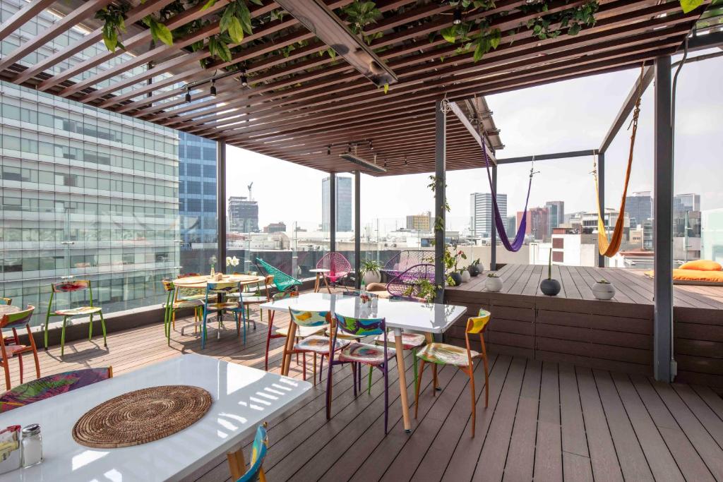 a balcony with tables and chairs on a building at FlowSuites WTC in Mexico City