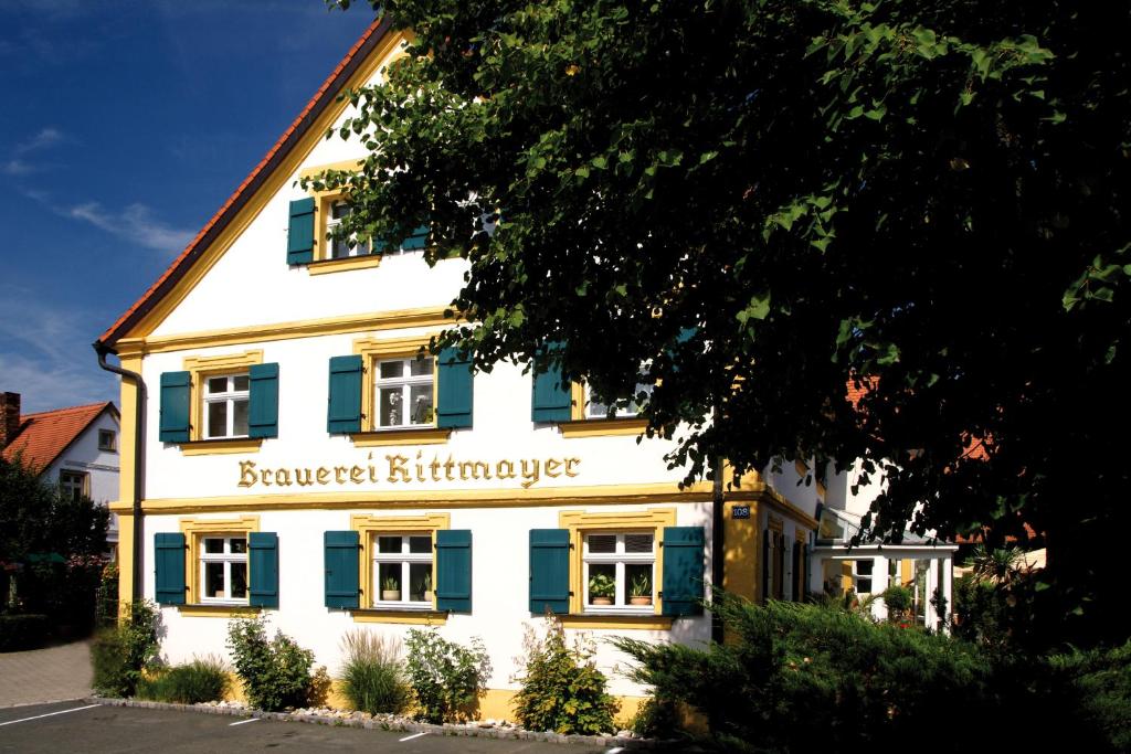 a white building with blue shutters on it at Landgasthof Hotel Rittmayer in Hallerndorf