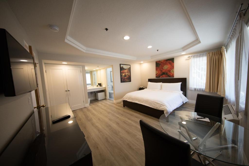 a bedroom with a bed and a desk with a computer at Wilshire Crest Hotel in Los Angeles