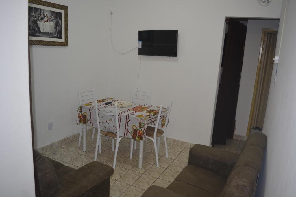 cocina con mesa con sillas y TV en Apartamento para 7 pessoas próximo a Basílica, en Aparecida