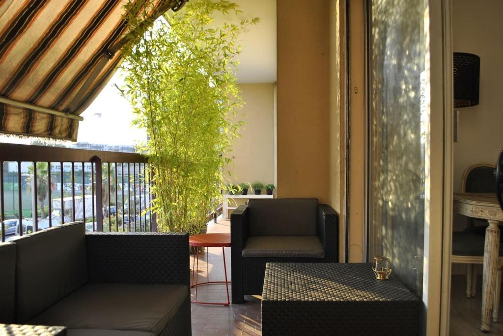 a living room with a chair and a table at Confortable, lumineux et fonctionnel in Nice