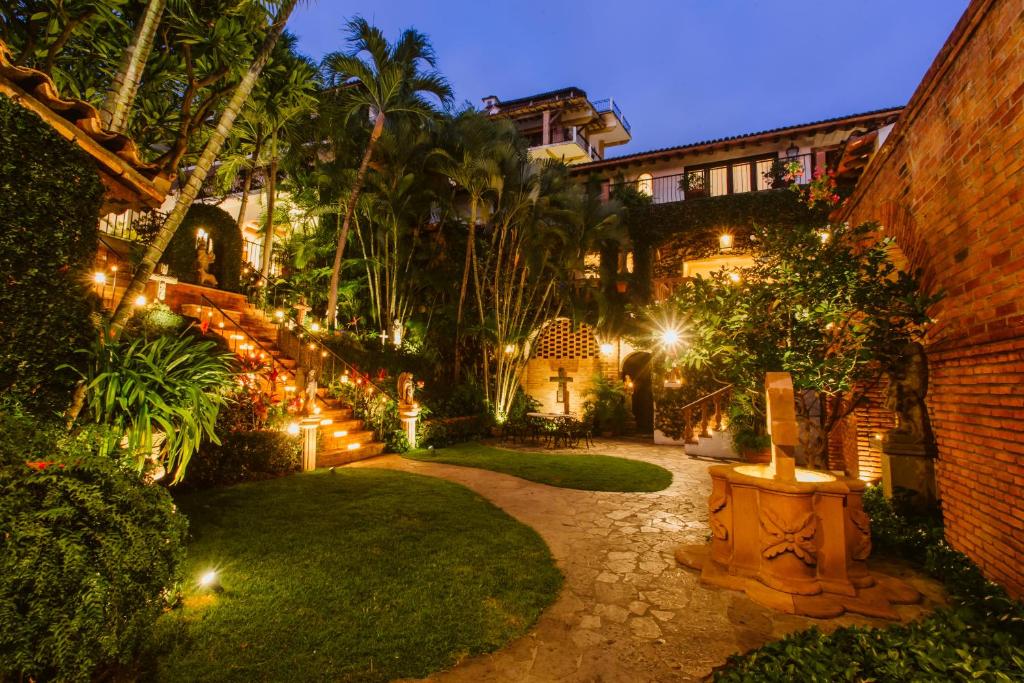 a garden at night with lights in a house at Hacienda San Angel in Puerto Vallarta