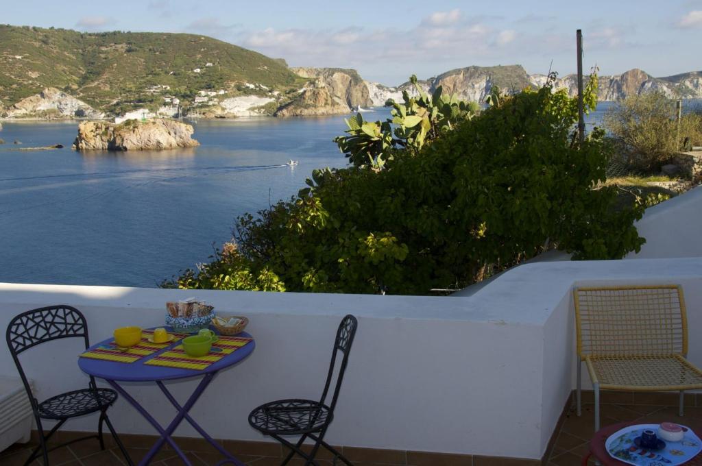 una mesa y sillas en un balcón con vistas al agua en B&B La Terrazza Sul Porto, en Ponza