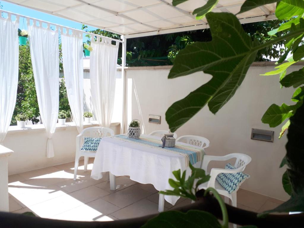 トッレ・スーダにあるResidence Salentoholidaysの窓付きの客室で、白いテーブルと椅子が備わります。