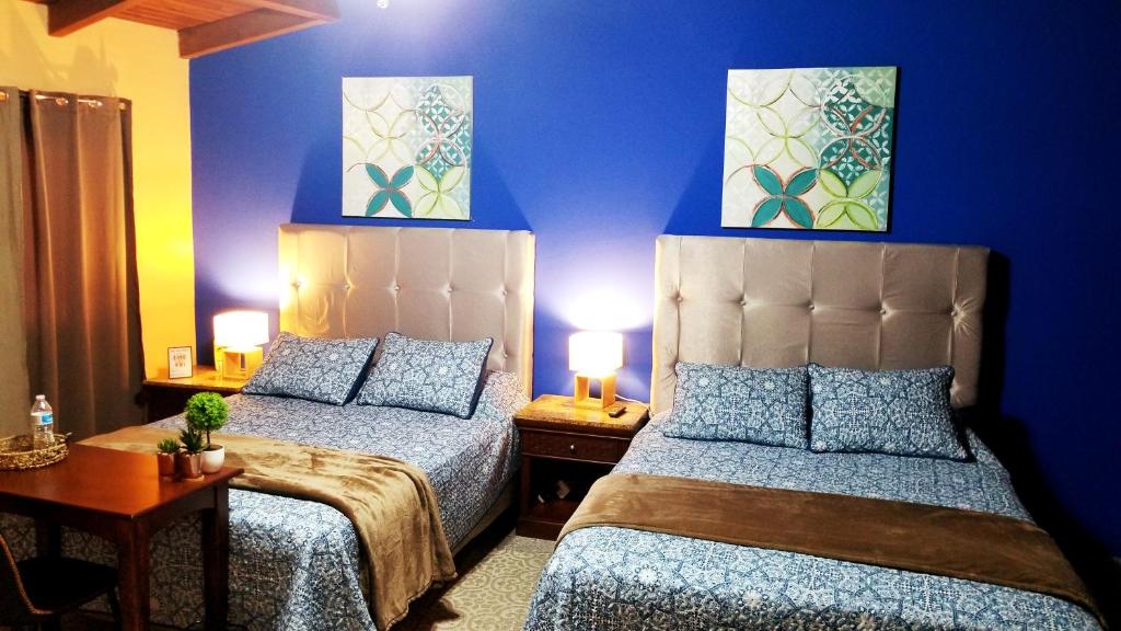 德古西加巴的住宿－Portal los Castaños，蓝色墙壁客房的两张床