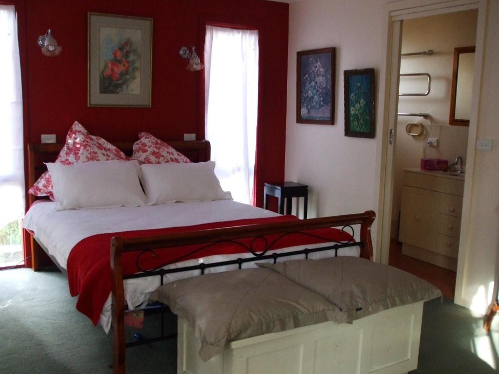 a bedroom with a large bed with red walls at At the Gallery in Torquay