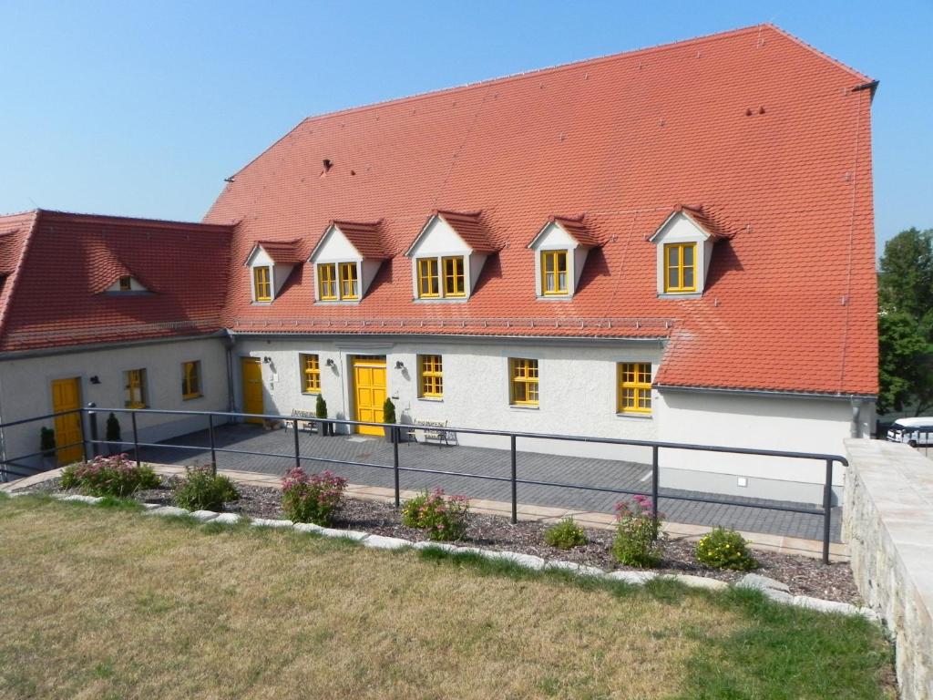 un grand bâtiment blanc avec un toit rouge dans l'établissement Hotel Altes Salzamt, à Bad Dürrenberg