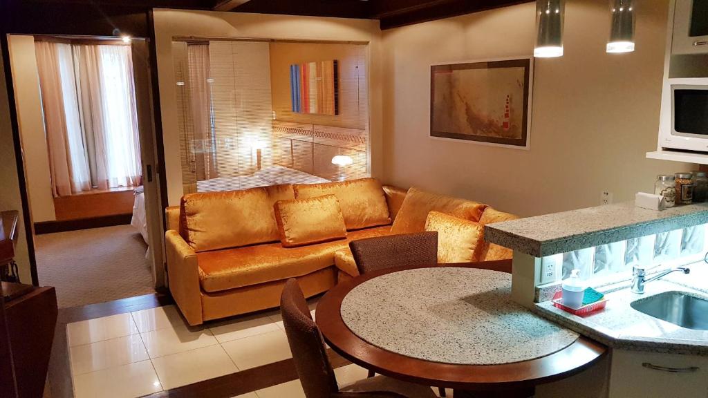sala de estar con sofá y mesa en Luxuoso Flat Mountain Village, en Canela