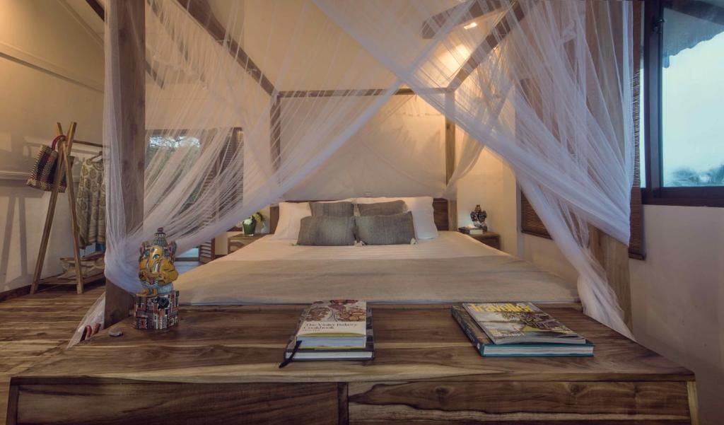 a bedroom with a bed with mosquito netting at C Beyond Nilaveli in Nilaveli