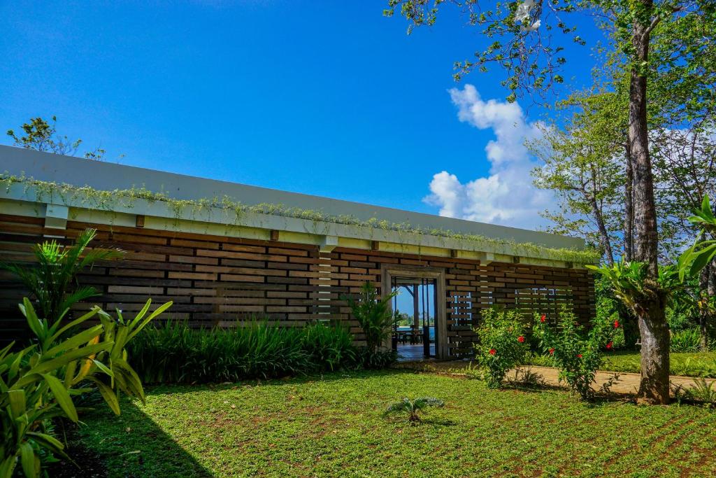 a wooden building with a garden in front of it at Naya Matahora Island Resort in Longga