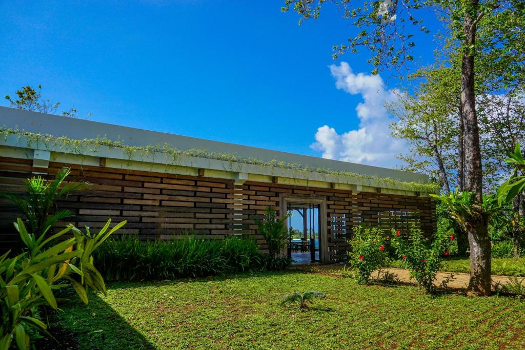 um edifício de madeira com um jardim em frente em Naya Matahora Island Resort em Longga