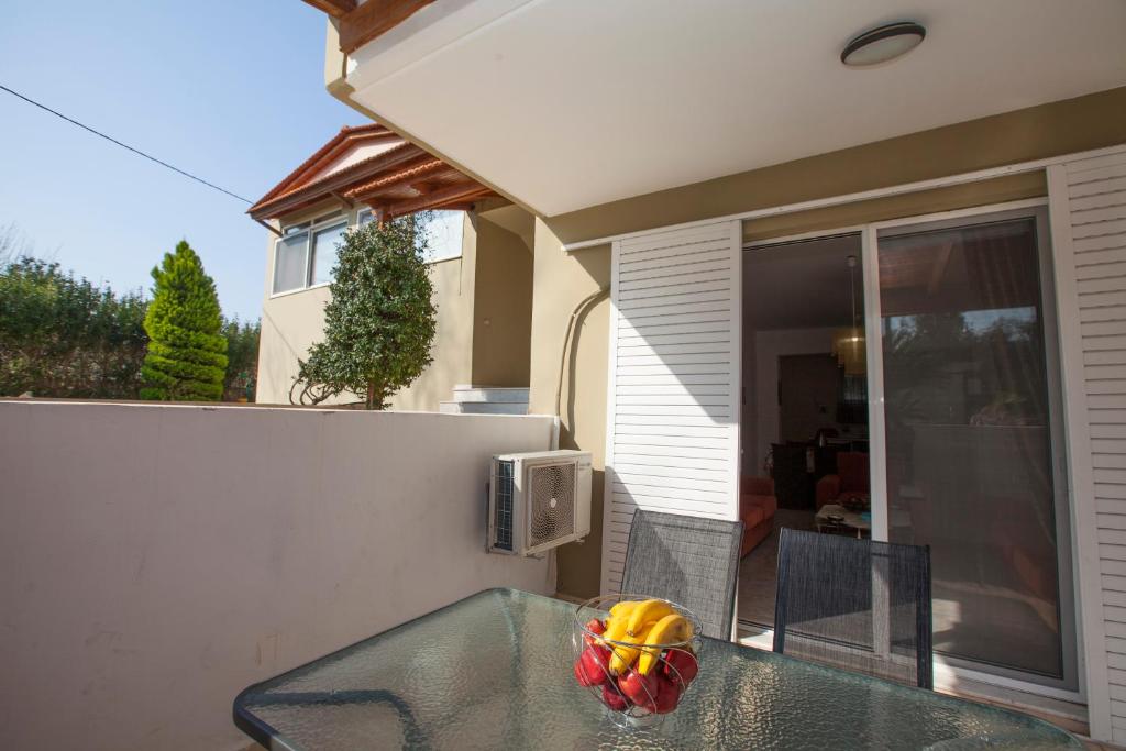 a glass table with a bowl of fruit on a balcony at Natural Quiet Accommodation in Kallithea Rhodes