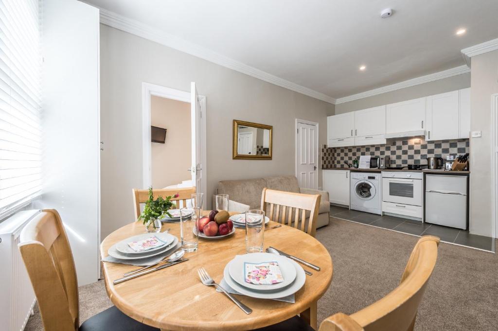a kitchen and dining room with a wooden table and chairs at Stylish Apartment,12 Minutes from Oxford Street,central London,ac,wifi! in London