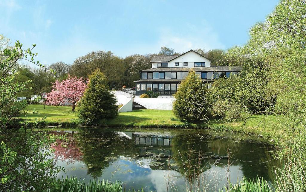 a large house with a pond in front of it at Damson Dene Hotel in Bowness-on-Windermere