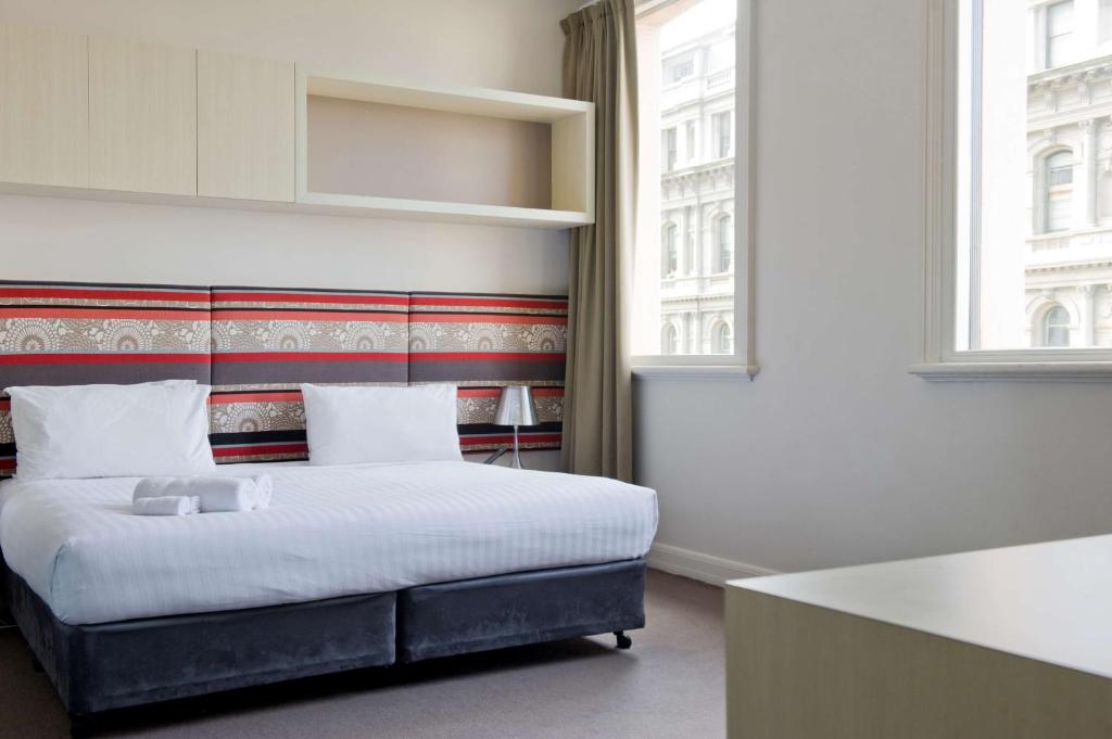 a bedroom with a bed and a large window at Best Western Melbourne City in Melbourne