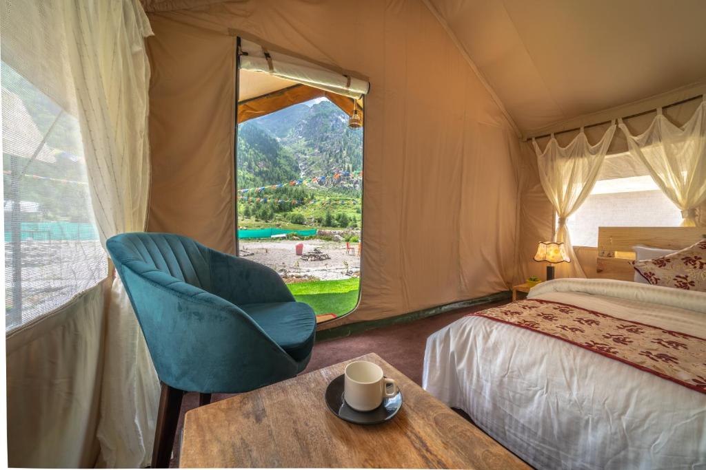 a bedroom with a bed and a chair and a table at Eskape Camps in Saturang