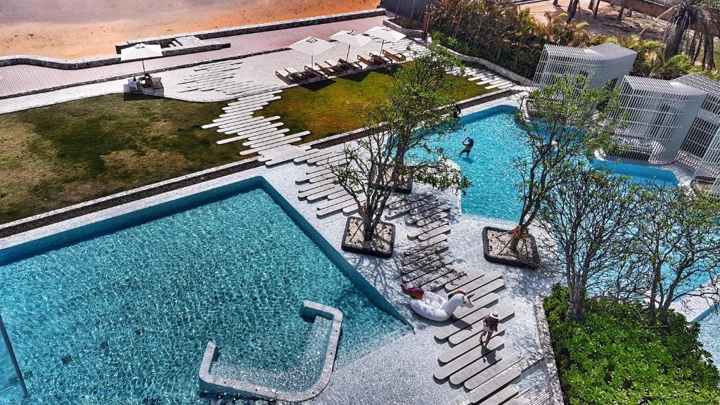 an overhead view of two pools with chairs and trees at VERANDA PATTAYA BY LUX - Beach Collection in Jomtien Beach