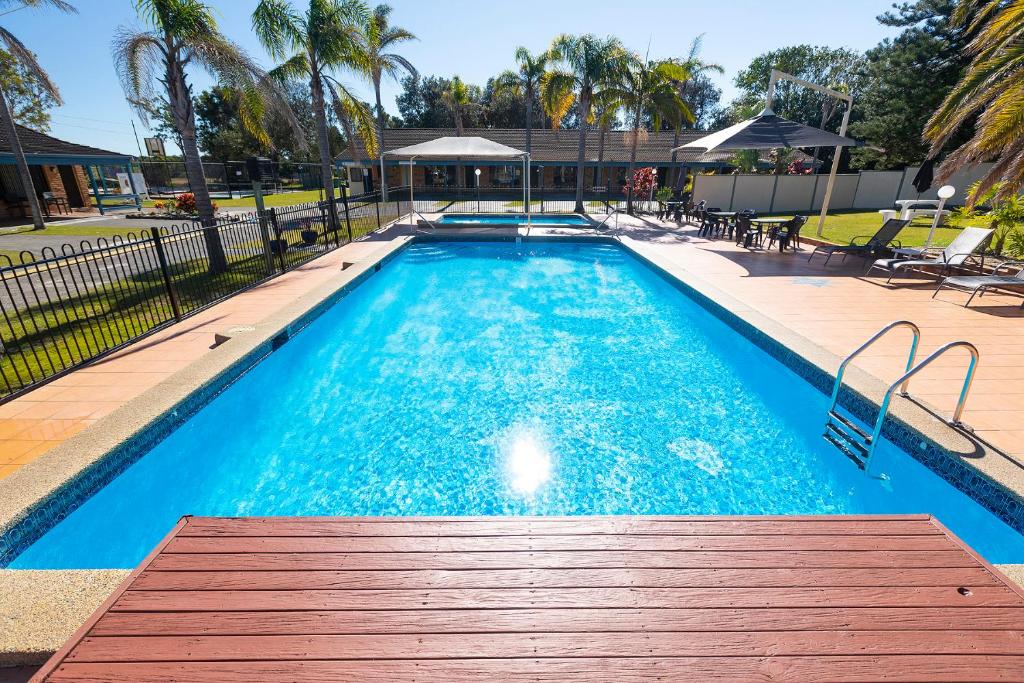- une grande piscine avec un banc en bois devant dans l'établissement Seashells Beachfront Resort, à Diamond Beach
