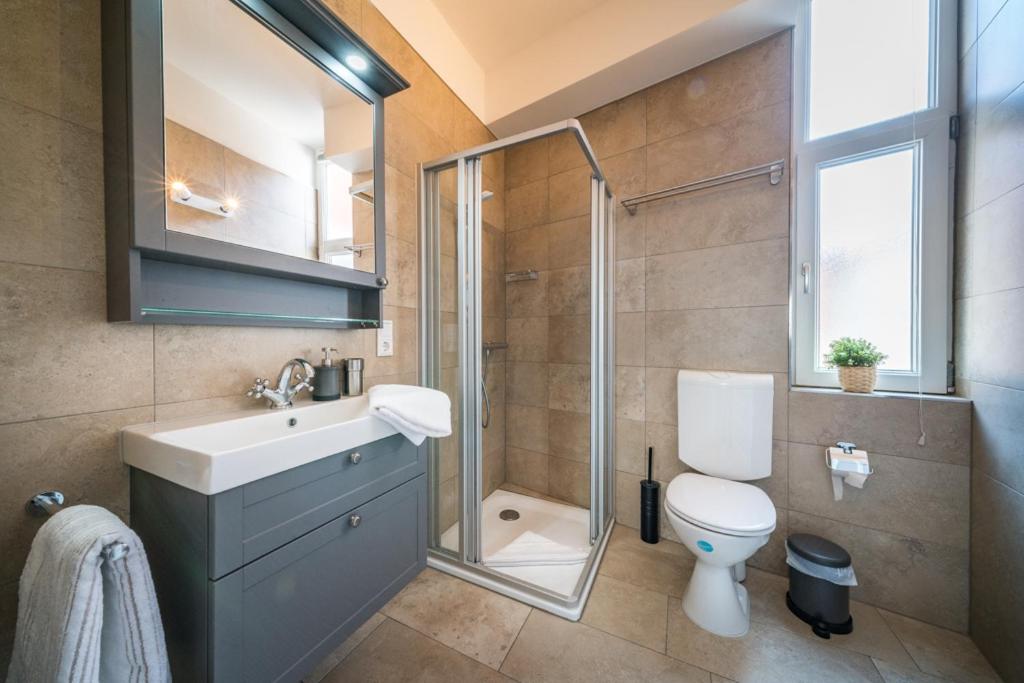 W łazience znajduje się toaleta, umywalka i prysznic. w obiekcie Villa Sofia w mieście Borkum