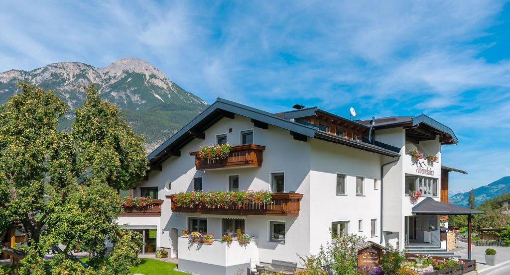 ein Gebäude mit Balkonen und Blumen vor einem Berg in der Unterkunft Albeinelerhof in Arzl im Pitztal