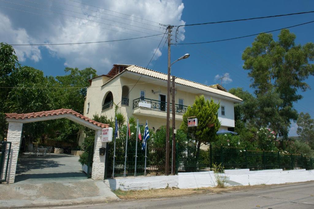 una casa con una valla y banderas delante de ella en Soldatos Rooms, en Marantochori